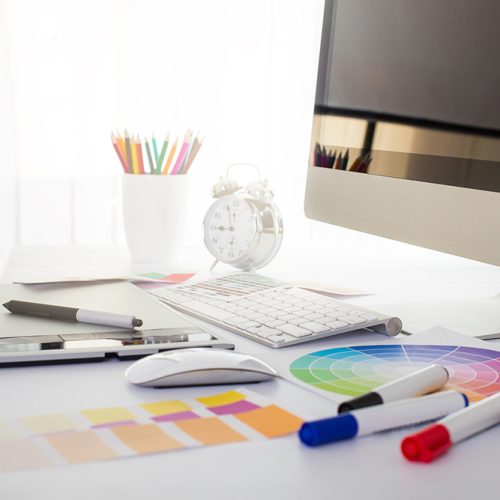 Modern office workplace with digital tablet, notepad, colorful pencils, glasses, in morning